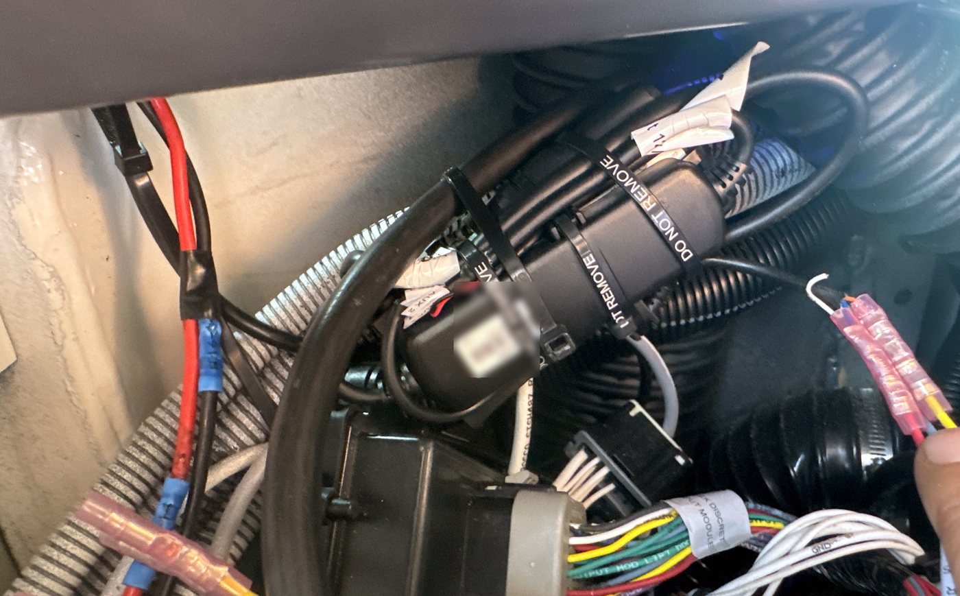 Telematics device strapped with DO NOT REMOVE ties, connections heat-shrunk