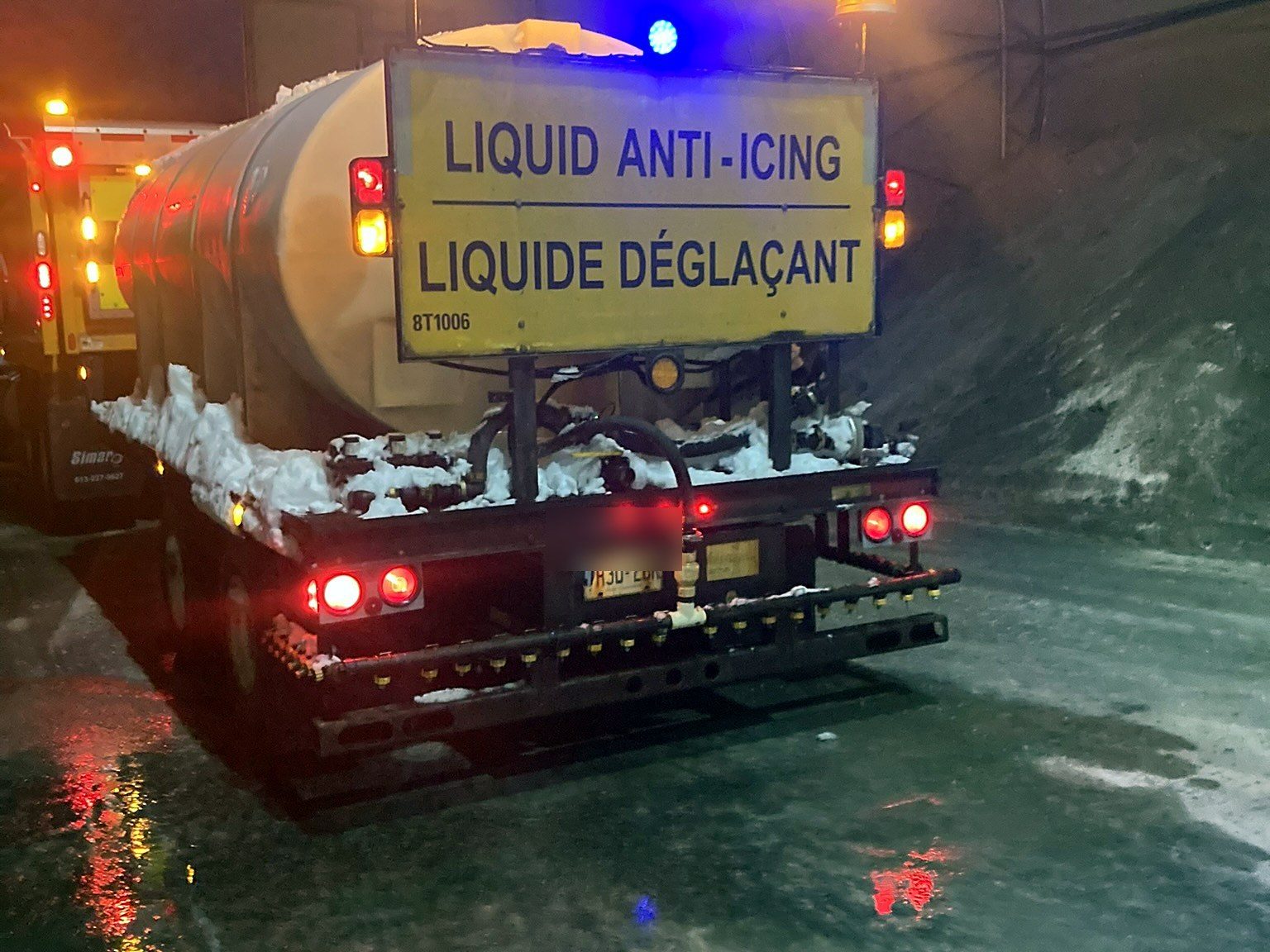 Brine trailer at night with beacons and tail lights on