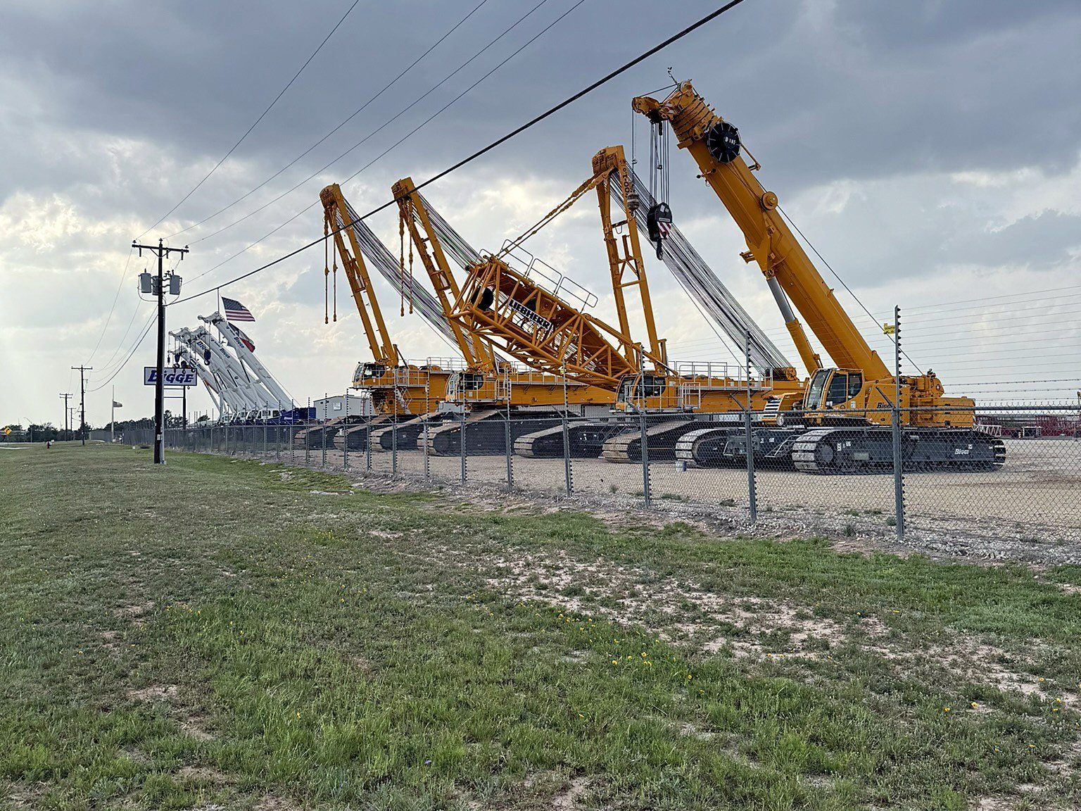 Row of crawler cranes in an equipment yard